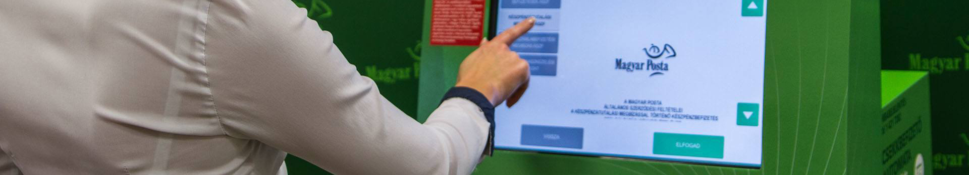 Csekkbefizető automata érintőképernyőjét érintő kéz