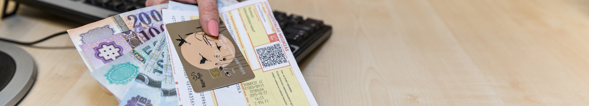 Készpénzt, bankkártyát és csekket tartó kéz