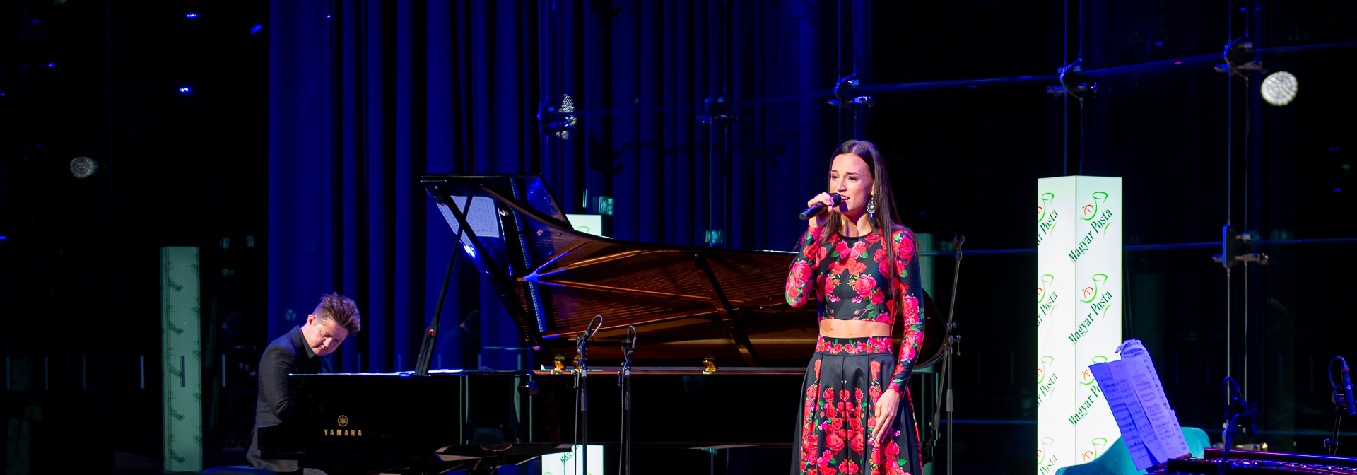 A képen Gubik Petra énekel egy Magyar Posta rendezvényen