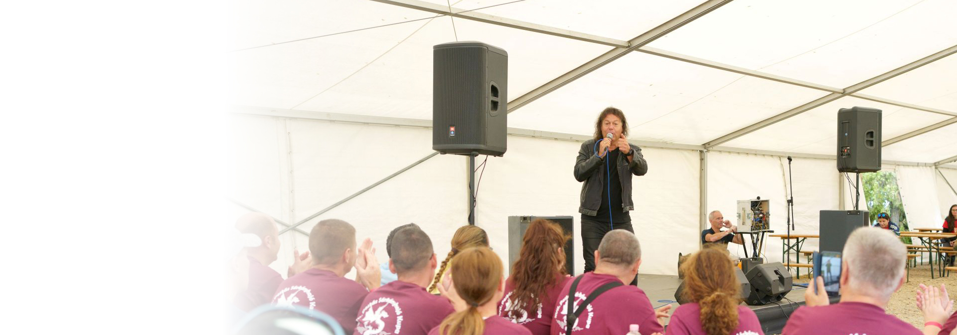 Hevesi Tamás énekel a fotón egy postai rendezvényen