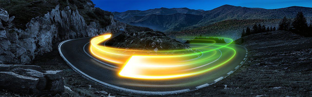 A képen hegyek láthatóak és a helyek között egy út, amelyen egy fénycsík jelzi a gyorsaságot.