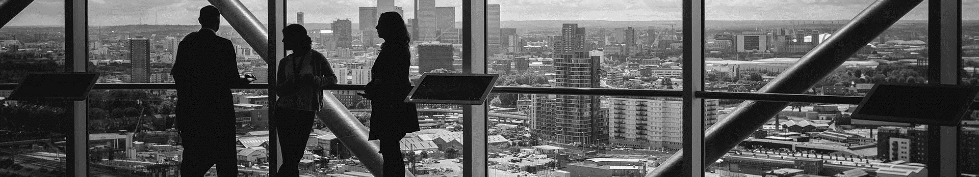 A képen egy irodaház abalkánál álló üzletemberek láthatóak.