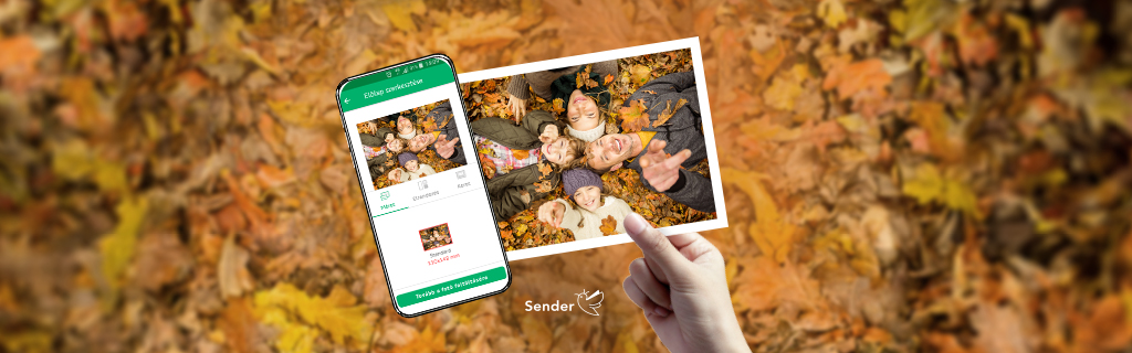 Tedd képeslappá az élményt! A képen őszi lehullott falevelek előtt egy kéz egy képeslapot tart, mellette egy mobiltelefonon a Sender applikáció látható