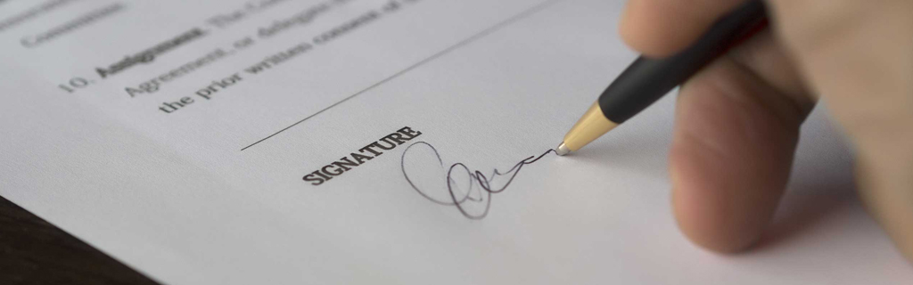 Általános szerződési feltételek. A képen egy szerződést aláíró kéz látható.
