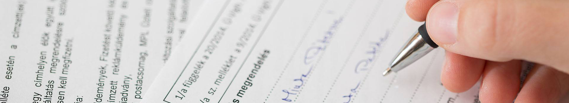 A képen egy nyomtatványt kitöltő kéz látható.